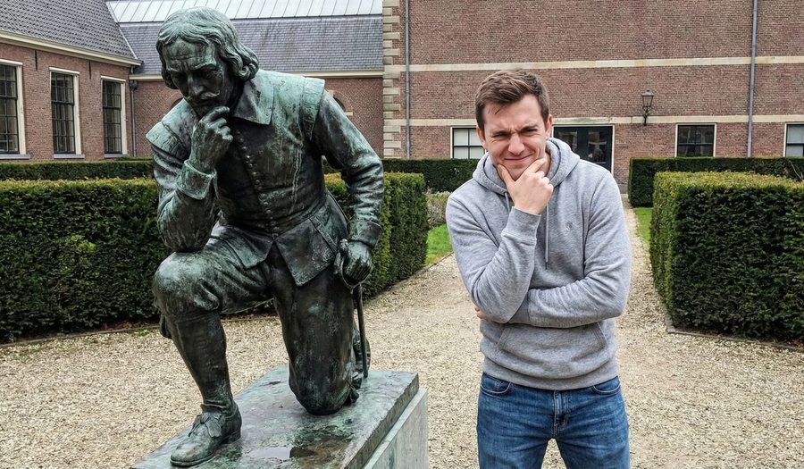 Speler poseert bij een standbeeld